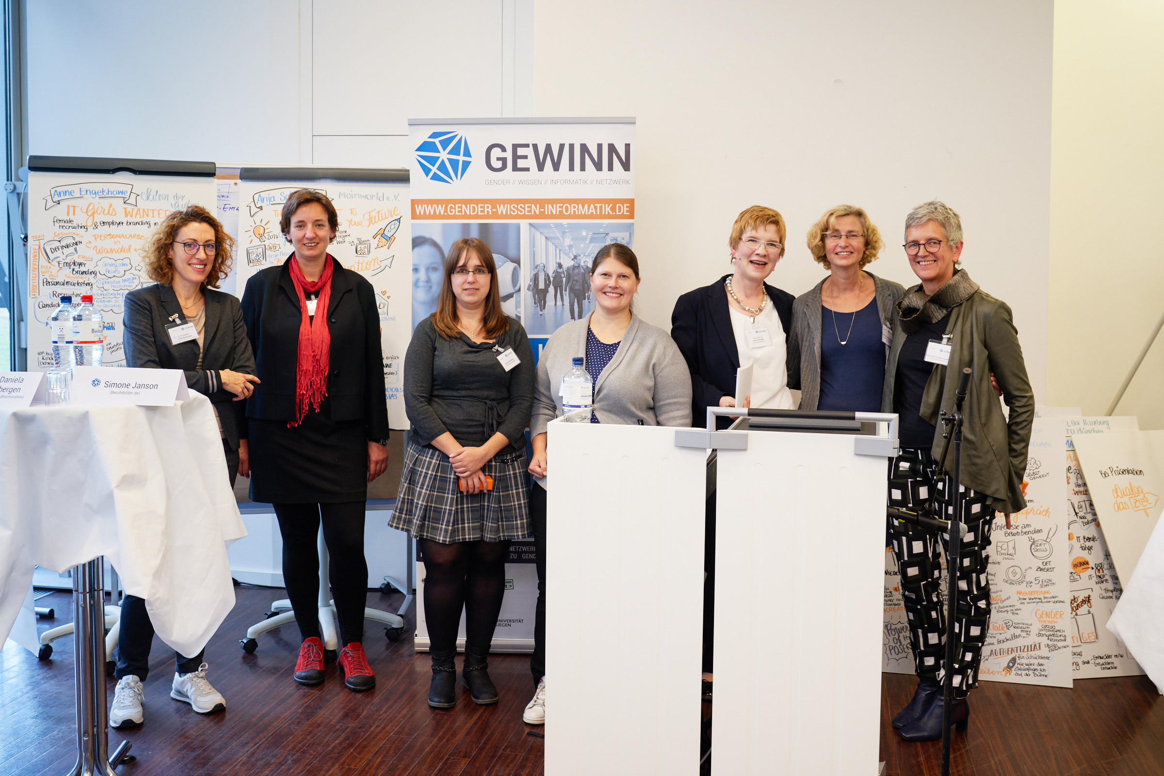 Sieben Referentinnen stehen vor dem Banner des Projekts "GEWINN".
